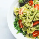 Pyszny obiad na redukcji: makaron farfalle z pesto, pomidorkami koktajlowymi i świeżą sałatą. Lekko i zdrowo!