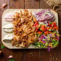 Pyszna shoarma z kurczaka na placku z warzywami i sosami. Idealna na szybki posiłek.