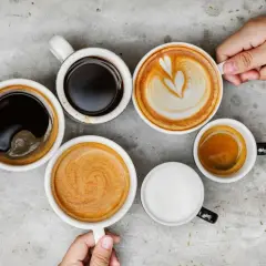 Różne rodzaje kawy, od espresso po latte, ułożone na szarym blacie. Czy kawa wypłukuje magnez? To pytanie nurtuje wielu miłośników tego napoju.