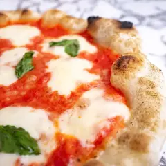 Pyszna pizza Margherita, klasyczny włoski przepis. Idealnie wypieczone ciasto, sos pomidorowy, mozzarella i świeża bazylia.