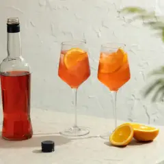 Butelka Aperolu i dwa drinki z pomarańczą, idealne na lato. Poznaj prosty aperol przepis!