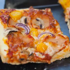 Domowa pizza na blachę, pachnąca świeżymi drożdżami, z pieczarkami, cebulą i pomidorkami. Idealna na rodzinny obiad.