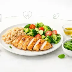 Na talerzu grillowany kurczak, brązowy ryż i świeża sałatka z brokułów, pomidorów i ogórka. Obok miseczka fasolki szparagowej i oliwa. Idealny, lekkostrawny obiad.