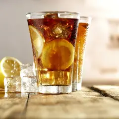 Orzeźwiający Long Island Ice Tea z cytryną i lodem na drewnianym blacie.