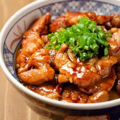 Miseczka z kurczakiem soboro w sosie teriyaki, posypana szczypiorkiem.