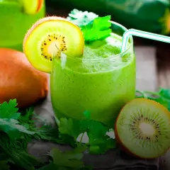 Zielony koktajl z kiwi i ziołami, udekorowany plasterkiem kiwi.