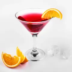 Elegancki, czerwony drink cosmopolitan z plasterkiem pomarańczy, obok kostki lodu i pomarańczy.