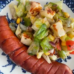 Jaka sałatka do szaszłyków? Lekka sałatka z grillowanym serem halloumi, sałatą, kukurydzą i pomidorkami świetnie pasuje do kiełbaski.