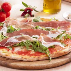 Pyszna pizza prosciutto z rukolą, pomidorami i oliwą z oliwek. Idealna na włoską ucztę.