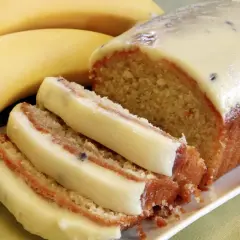 Szybkie ciasto z bananami i budyniem, z kremowym lukrem i kawałkami owoców. Idealne na deser.