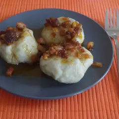 Pyzy z mięsem, przepis Siostry Anieli, polane skwarkami i sosem. Pyszne danie na talerzu.