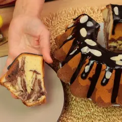 Wilgotna babka marmurkowa na oleju, polana czekoladą i posypana płatkami migdałów, prezentuje swoje piękne, czekoladowo-waniliowe wzory.