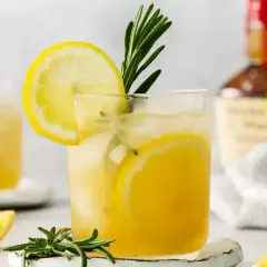 Orzeźwiający limoncello spritz z plasterkami cytryny i gałązką rozmarynu, idealny na letnie popołudnie.