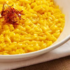 Aksamitne risotto alla milanese, złociste i aromatyczne, ozdobione nitkami szafranu.