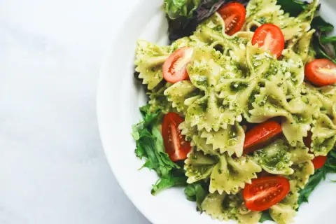 Pyszny obiad na redukcji: makaron farfalle z pesto, pomidorkami koktajlowymi i świeżą sałatą. Lekko i zdrowo!