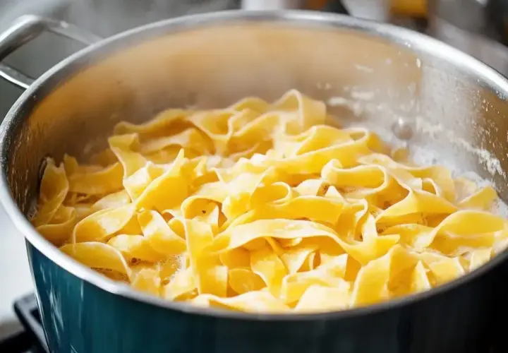 Szeroki makaron tagliatelle gotuje się w bulgoczącej wodzie. Tak właśnie wrzuca się makaron do gotującej wody, by był idealnie al dente.