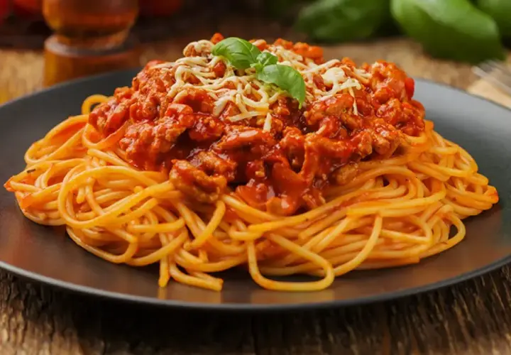 Pyszne spaghetti bolognese z mielonym mięsem, pomidorowym sosem i parmezanem. Idealne pytanie: jakie mięso do spaghetti? Odpowiedź: mielone!