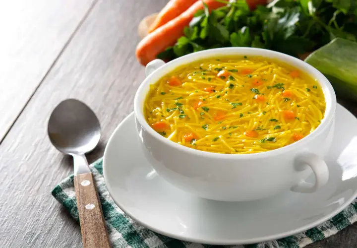 Aromaticzny rosół z makaronem, z kawałkami marchewki i natką pietruszki. Idealny na lekki posiłek, z niską zawartością kcal.