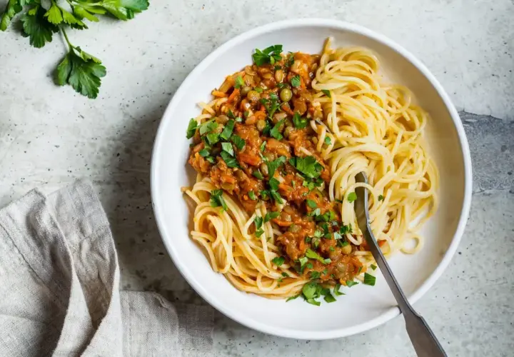 Porcja spaghetti z sosem z soczewicy i warzyw. Zastanawiasz się, ile węglowodanów ma makaron?