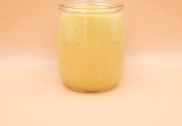 Gęsty, kremowy mango lassi w szklanym słoiku, gotowy do orzeźwiającego łyku.