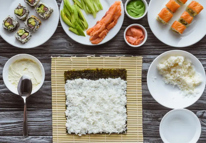 Składniki do sushi i risotto: ryż, łosoś, awokado, nori, wasabi, imbir, serek.