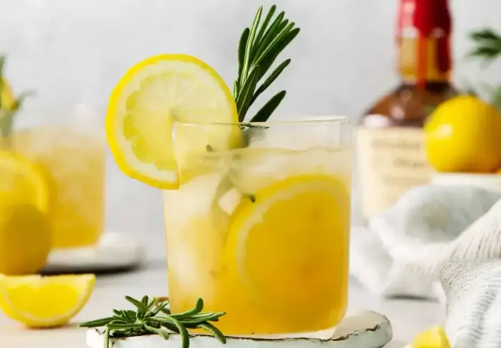 Orzeźwiający limoncello spritz z plasterkami cytryny i gałązką rozmarynu, idealny na letnie popołudnie.