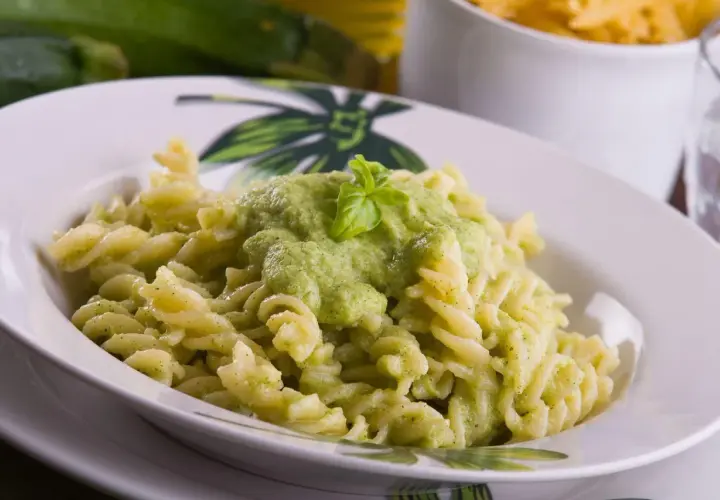 Pyszny makaron fusilli z kremowym sosem z cukinii, udekorowany listkiem bazylii. Idealny na szybki obiad.