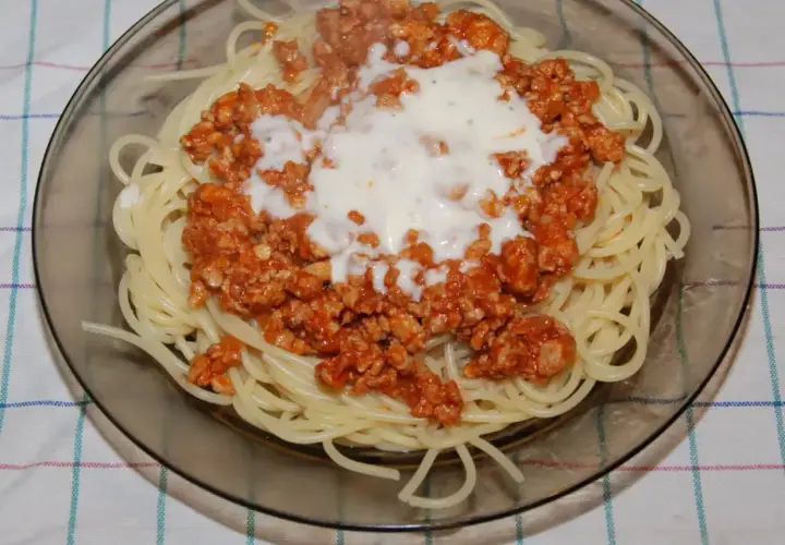Spaghetti z sosem bolognese. Mięso mielone doprawione do smaku, podane z makaronem i sosem śmietanowym.