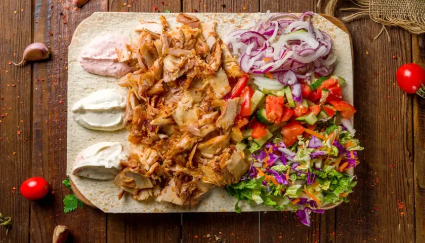 Pyszna shoarma z kurczaka na placku z warzywami i sosami. Idealna na szybki posiłek.