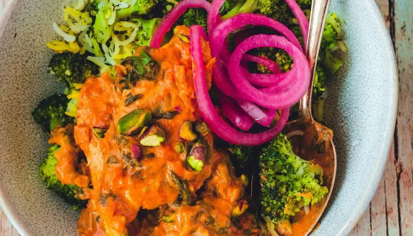Pyszny ryż z curry, podany z brokułami, pistacjami i marynowaną czerwoną cebulą.