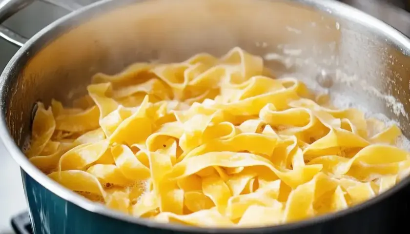 Szeroki makaron tagliatelle gotuje się w bulgoczącej wodzie. Tak właśnie wrzuca się makaron do gotującej wody, by był idealnie al dente.