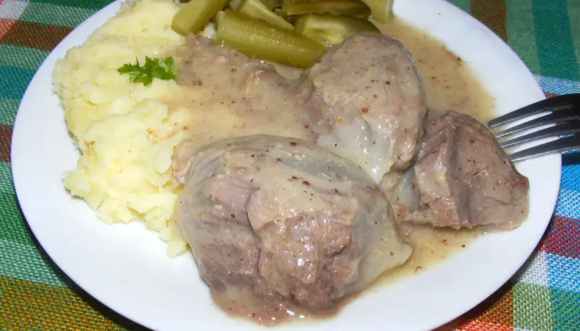 Na talerzu puree ziemniaczane, sos i żołądki z indyka, obok ogórki kiszone.