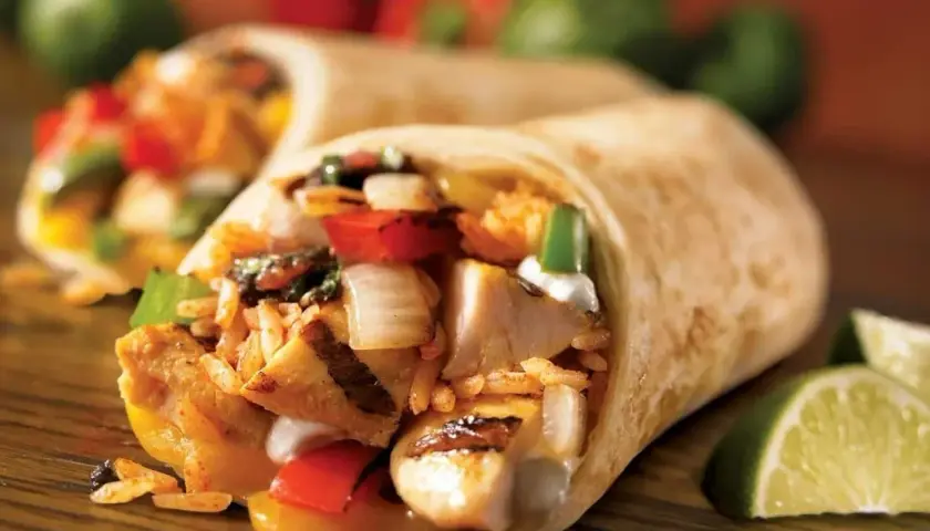 Pyszna tortilla z kurczakiem na ciepło, ryżem, warzywami i serem. Idealna na szybki posiłek.