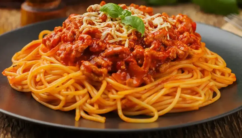 Pyszne spaghetti bolognese z mielonym mięsem, pomidorowym sosem i parmezanem. Idealne pytanie: jakie mięso do spaghetti? Odpowiedź: mielone!