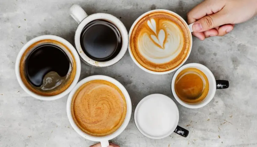 Różne rodzaje kawy, od espresso po latte, ułożone na szarym blacie. Czy kawa wypłukuje magnez? To pytanie nurtuje wielu miłośników tego napoju.