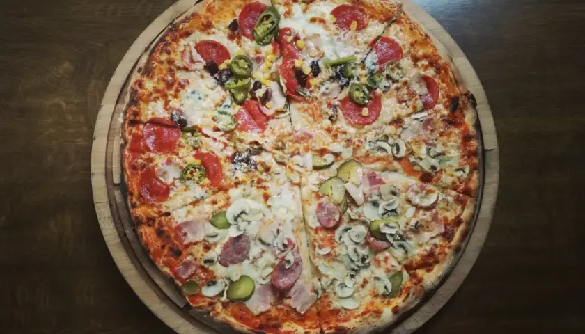 Pyszna pizza z salami, pieczarkami, korniszonami i kukurydzą. Idealna na wieczór, choć warto pamiętać o jej pizza kcal.