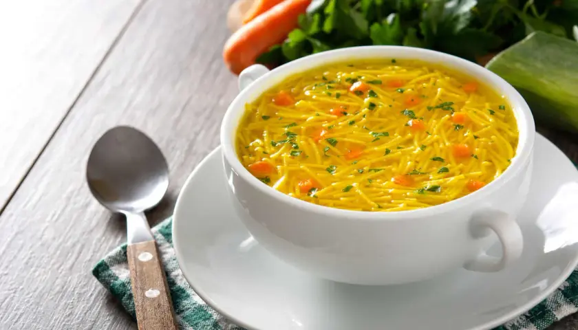 Aromaticzny rosół z makaronem, z kawałkami marchewki i natką pietruszki. Idealny na lekki posiłek, z niską zawartością kcal.