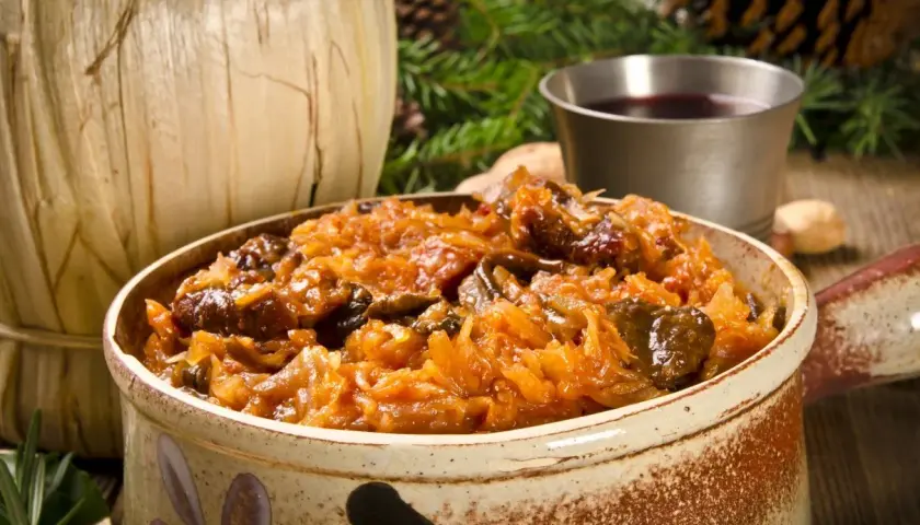 Tradycyjny bigos z różnymi rodzajami mięsa, podany w glinianym naczyniu. Idealne danie, gdy zastanawiasz się, jakie mięso do bigosu wybrać.