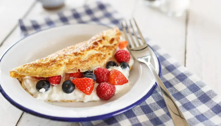 Słodki omlet z serkiem i owocami leśnymi, idealny na śniadanie. Ten przepis na omlet na słodko zachwyci każdego!