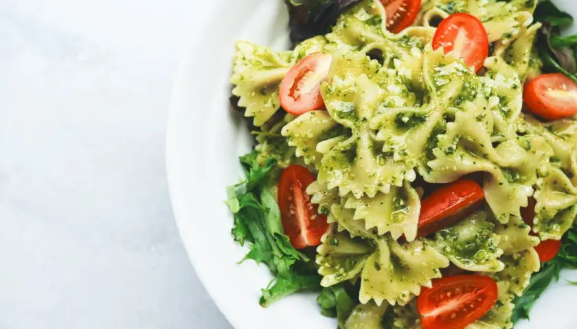 Pyszny obiad na redukcji: makaron farfalle z pesto, pomidorkami koktajlowymi i świeżą sałatą. Lekko i zdrowo!