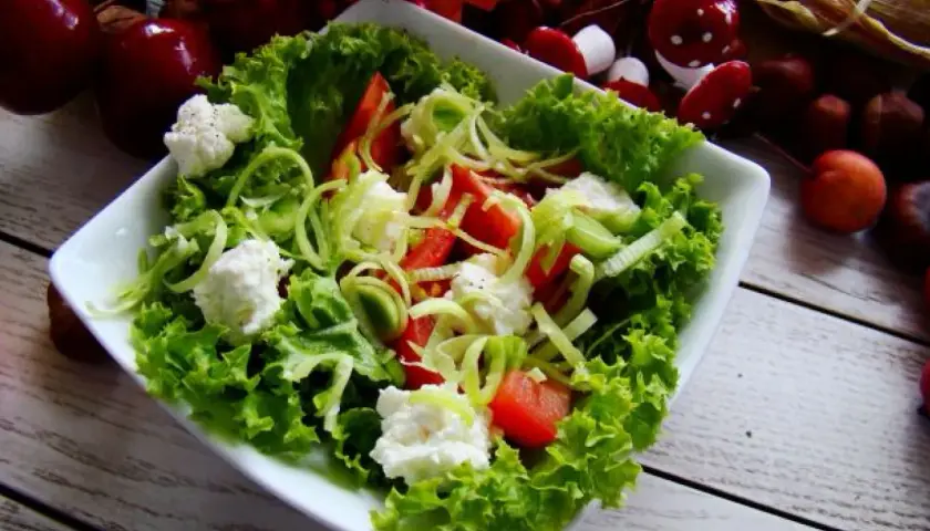 Sałatka z chrupiącą sałatą karbowaną, pomidorami i serem feta. Idealna na lekki posiłek.