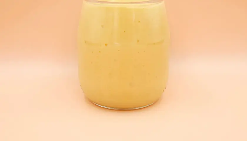 Gęsty, kremowy mango lassi w szklanym słoiku, gotowy do orzeźwiającego łyku.