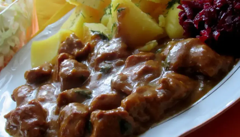 Gulasz z łopatki wieprzowej w sosie własnym, podany z ziemniakami i buraczkami. Pyszne, domowe danie.