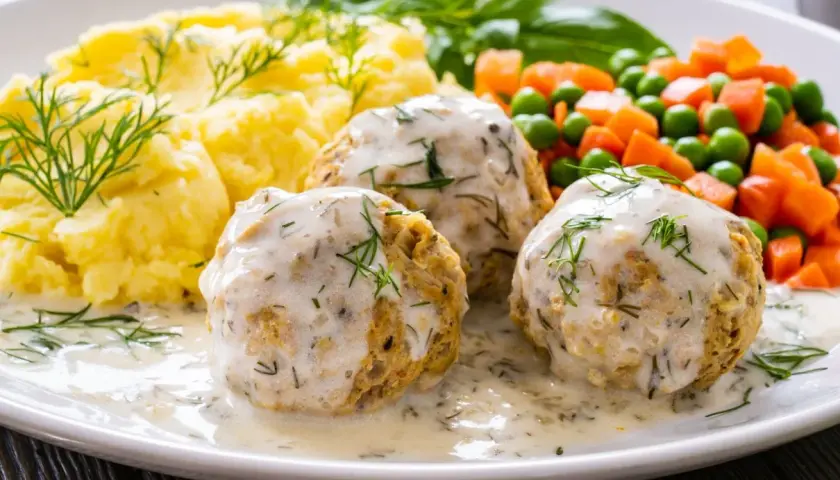 Pyszne pulpety z indyka w sosie koperkowym, podane z puree ziemniaczanym i warzywami.