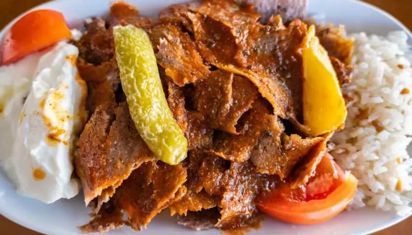 Pyszny kebab z mięsa mielonego z ryżem, jogurtem, pomidorem i ogórkiem.