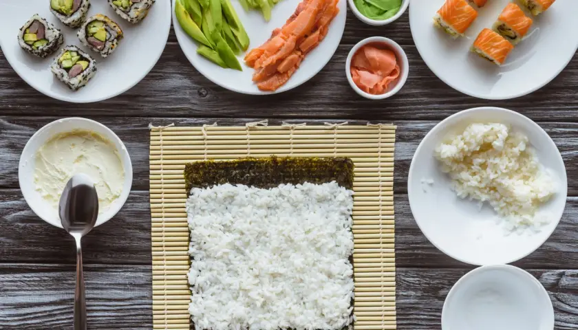 Składniki do sushi i risotto: ryż, łosoś, awokado, nori, wasabi, imbir, serek.