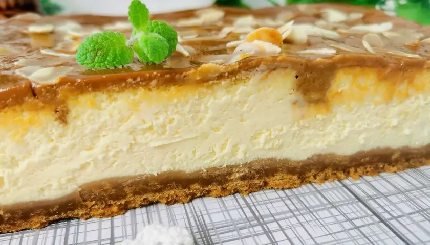 Pyszny sernik z mascarpone i budyniem, z polewą karmelową i migdałami. Idealny przepis na deser.