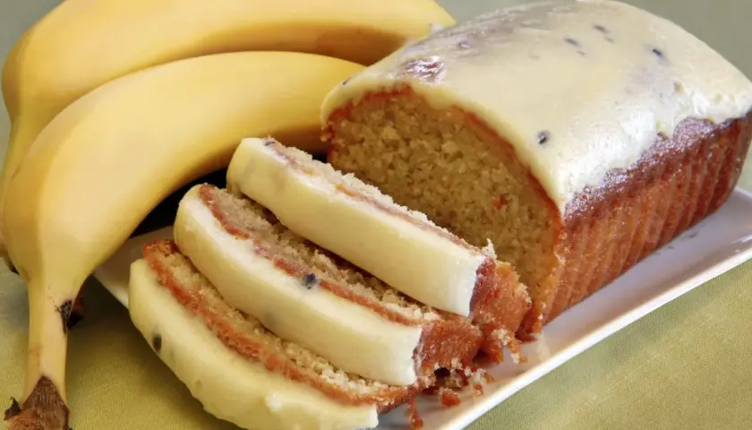 Szybkie ciasto z bananami i budyniem, z kremowym lukrem i kawałkami owoców. Idealne na deser.
