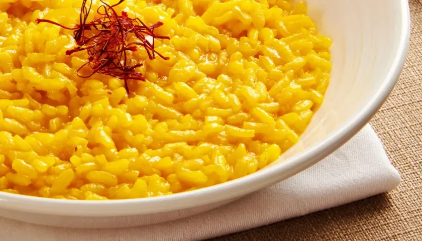 Aksamitne risotto alla milanese, złociste i aromatyczne, ozdobione nitkami szafranu.