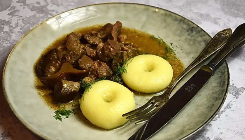 Gulasz z dzika z kluskami śląskimi i koperkiem. Aromatyczne danie, które rozpływa się w ustach.